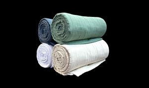 The SONU Muslin Blanket, photo of white, ivory, sage and pacific colors.